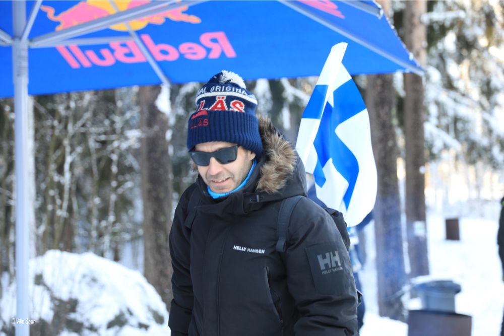 Mies Red Bull -varjon alla talvisessa metsässä